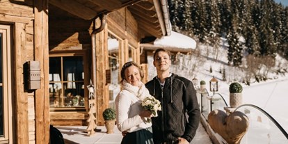 Winterhochzeit - Garten - Das glückliche Brautpaar auf der Sonnenterrasse der Rössl Alm. - Rössl Alm