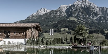 Winterhochzeit - Art der Location: Alm - Berchtesgaden - Badhaus mit Badeteich und den Leoganger Steinbergen im Hintergrund. - PURADIES Hotel & Chalets