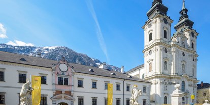 Winterhochzeit - Personenanzahl - Alpenregion Nationalpark Gesäuse - Hoteleingang mit der wunderschönen Stiftskirche - JUFA Hotel Pyhrn Priel