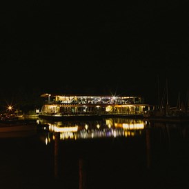 Hochzeitslocation: Das Seerestaurant Katamaran am Neusiedlersee bei Nacht.
 - Seerestaurant Katamaran