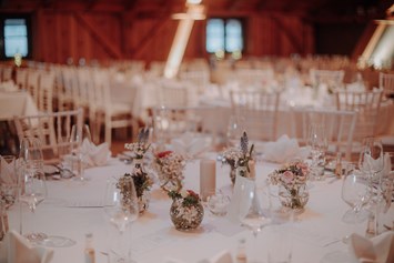 Hochzeitslocation: Runder Tisch mit kleiner Tischdekoration in der Eventtenne - Eventtenne - Hochzeits- & Veranstaltungslocation