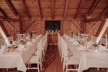 Hochzeitslocation: Lange Tafeln in den Seitennischen der Tenne - Eventtenne - Hochzeits- & Veranstaltungslocation