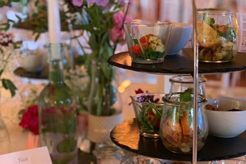 Hochzeitslocation: Vorspeisenbuffet auf den Gasttischen elegant angerichtet auf schönen Etageren - Eventtenne - Hochzeits- & Veranstaltungslocation