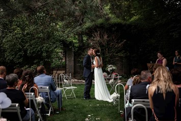 Hochzeitslocation: Der Erste Kuss als Vermähltes Paar inmitten der großen Gartenlandschaft des Junghof in Undenheim. - JUNGHOF Weingut & Gutsgastronomie