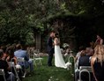 Hochzeitslocation: Der Erste Kuss als Vermähltes Paar inmitten der großen Gartenlandschaft des Junghof in Undenheim. - JUNGHOF Weingut & Gutsgastronomie