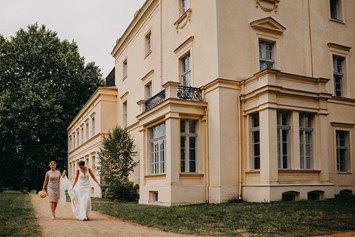 Hochzeitslocation: Die Braut auf dem Weg zur Trauung im Schlossgarten. - Schloss Steinhöfel