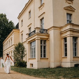 Hochzeitslocation: Die Braut auf dem Weg zur Trauung im Schlossgarten. - Schloss Steinhöfel
