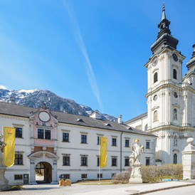 Hochzeitslocation: Hoteleingang mit der wunderschönen Stiftskirche - JUFA Hotel Pyhrn Priel