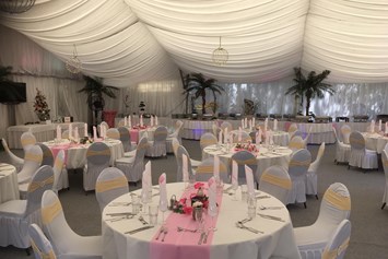 Hochzeitslocation: Ein dekorierter Hochzeitssaal in romantischen rosa mit direkten blick zum Wasser.  - Flasch City am Freizeitsee