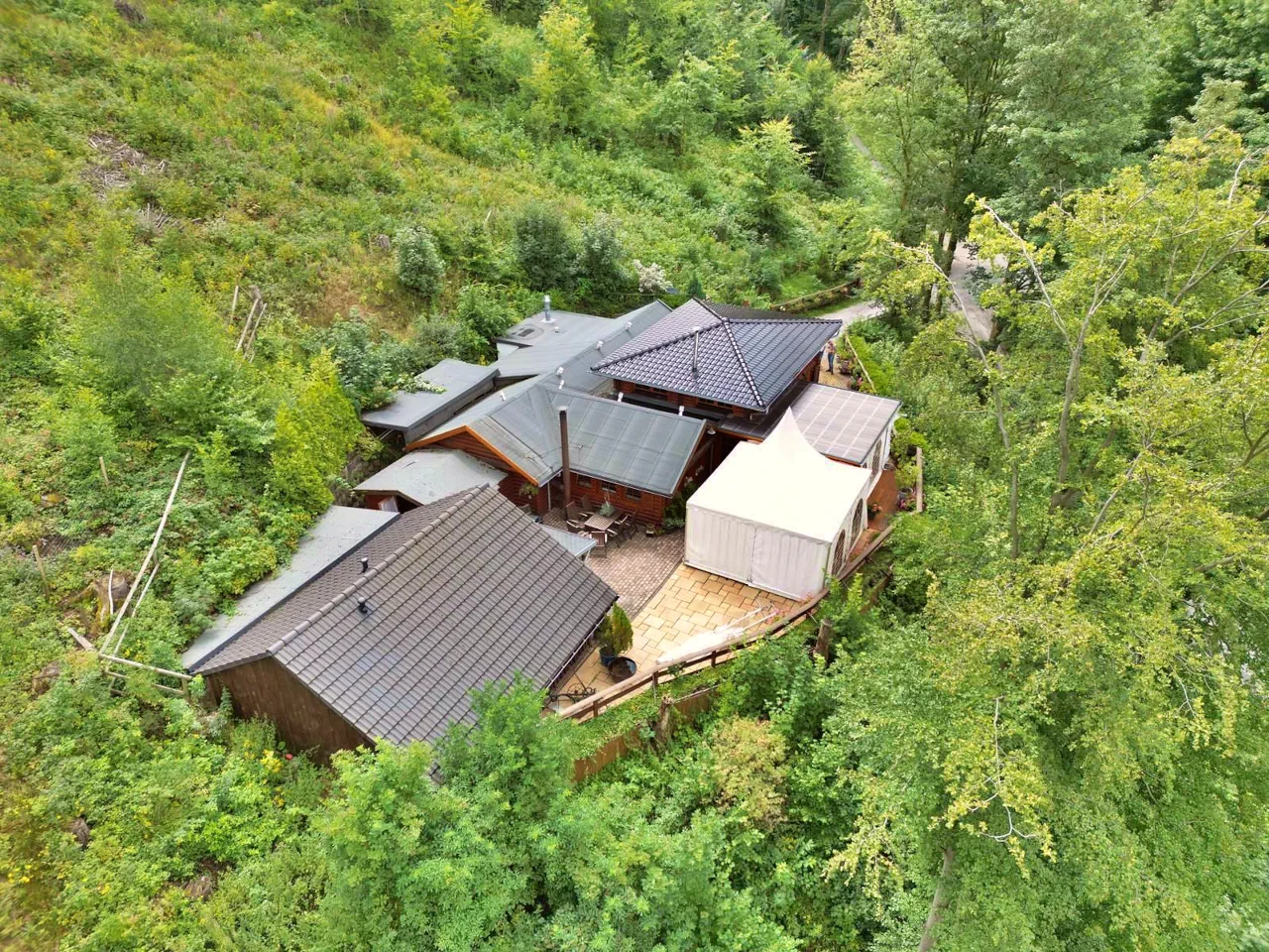 Hochzeitslocation: Wenn wir sagen, unsere Hütte liegt mitten im Wald - dann meinen wir das auch genauso! Auf dem Bild ist zudem das Außenzelt zu sehen, sofern dieses gewünscht ist. - Brilons Kurparkhütte