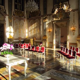 Hochzeitslocation: Der Marmorsaal wird oft als der schönste Trauungssaal Europas bezeichnet. Hier erwacht der weltberühmte Saal in dem schon W.A. Mozart mit seiner Familie musiziert hat im Morgenlicht.  - Schloss Mirabell